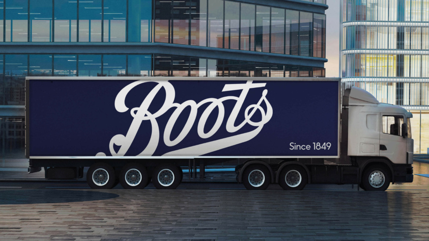 "Boots lorry stationed outside some highrise office buildings."