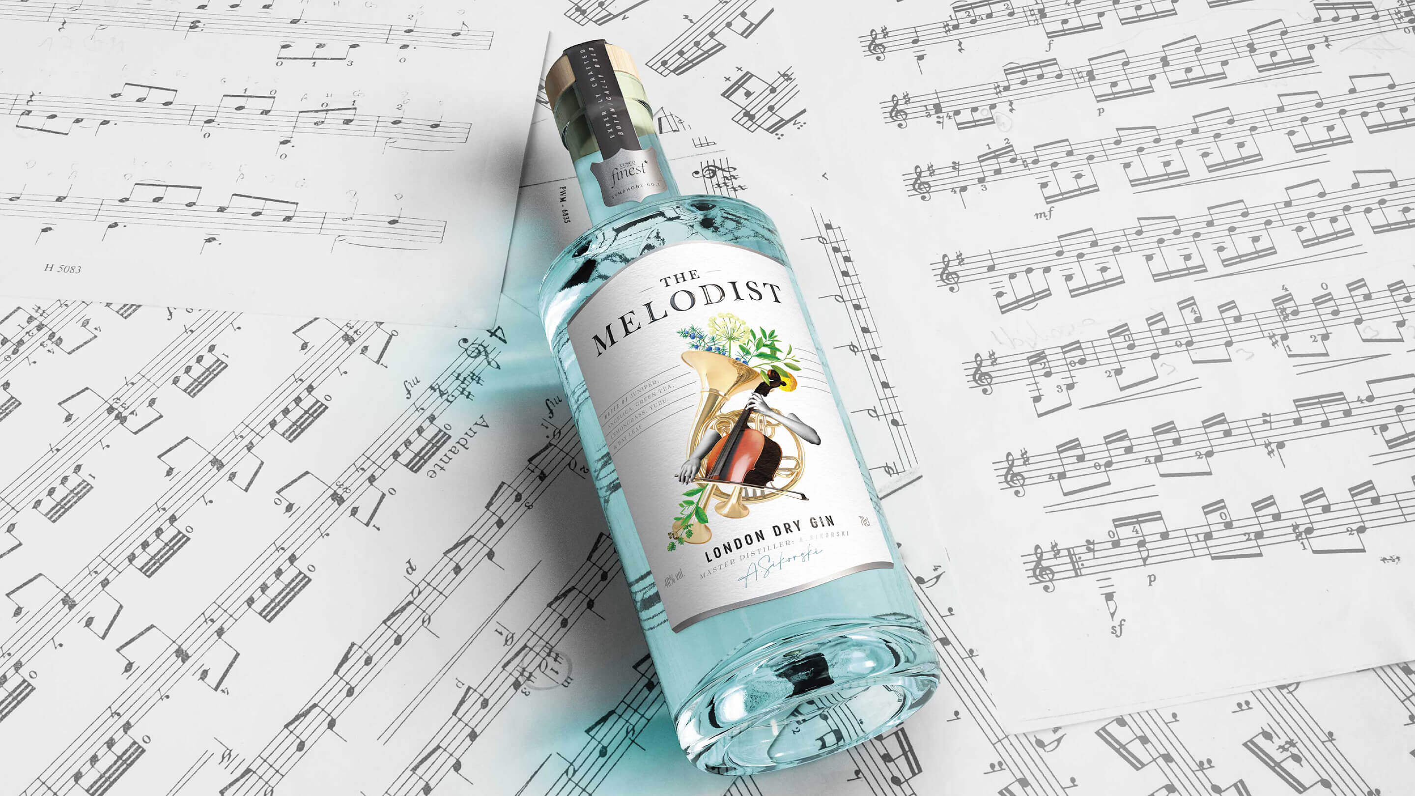 The Molodist - A bottle of London dry gin on a stack of music sheets