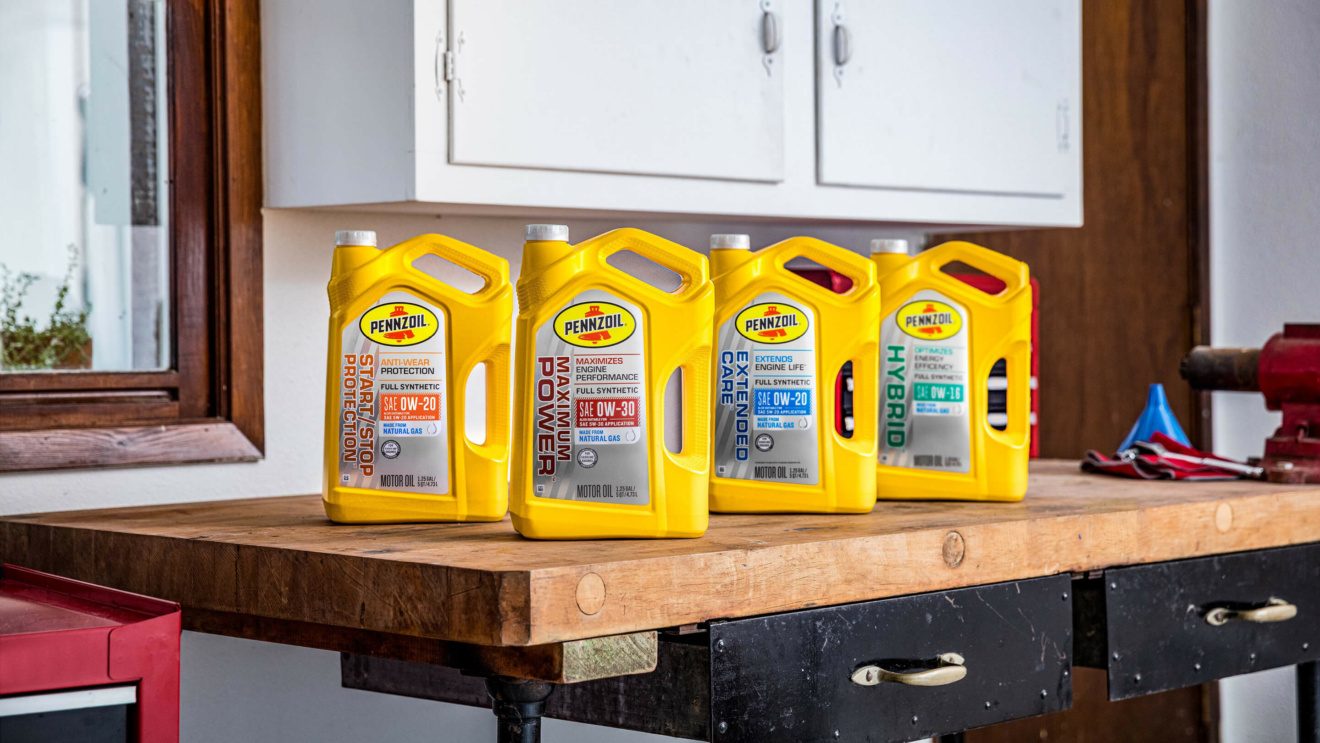 4 Pennzoil motor oil canisters placed on a workbench.