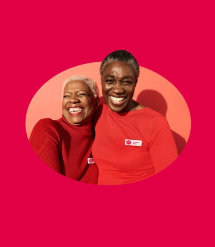 2 Post office employees wearing red jumpers on a red background