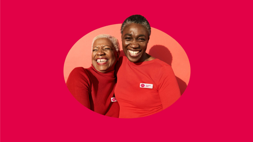 2 Post office employees wearing red jumpers on a red background