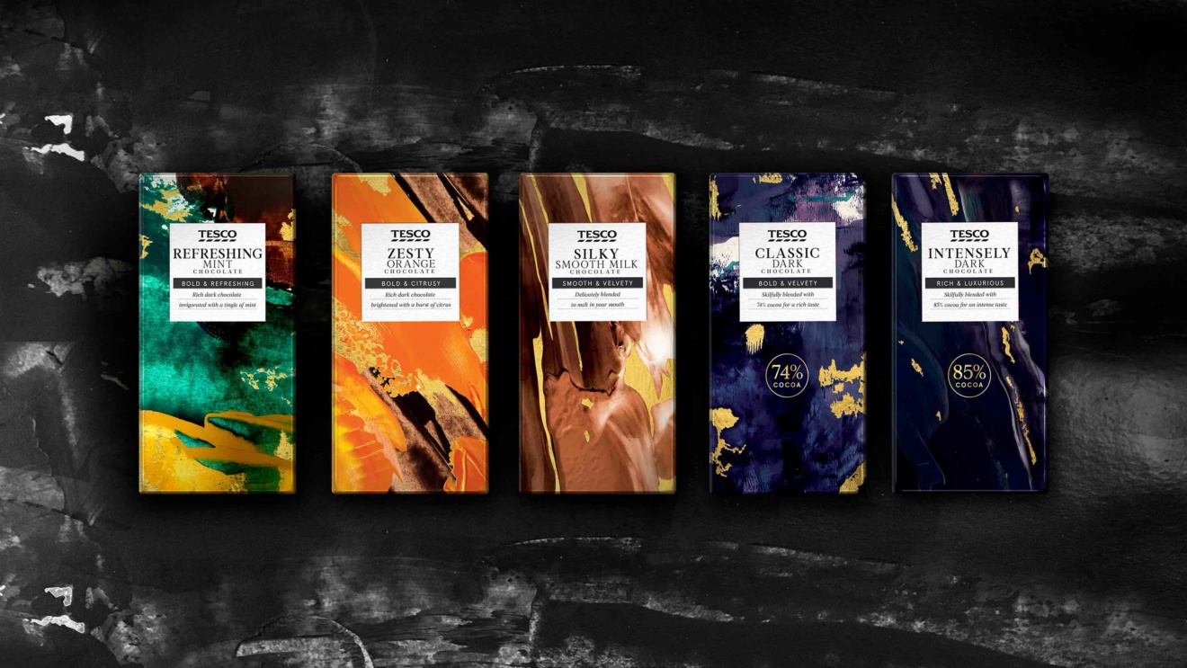 "A selection of Tesco chocolate bars, including Refreshing Mint, Zesty Orange, Silky Smooth Milk, Classic Dark, and Intensely Dark, displayed on a dark background."