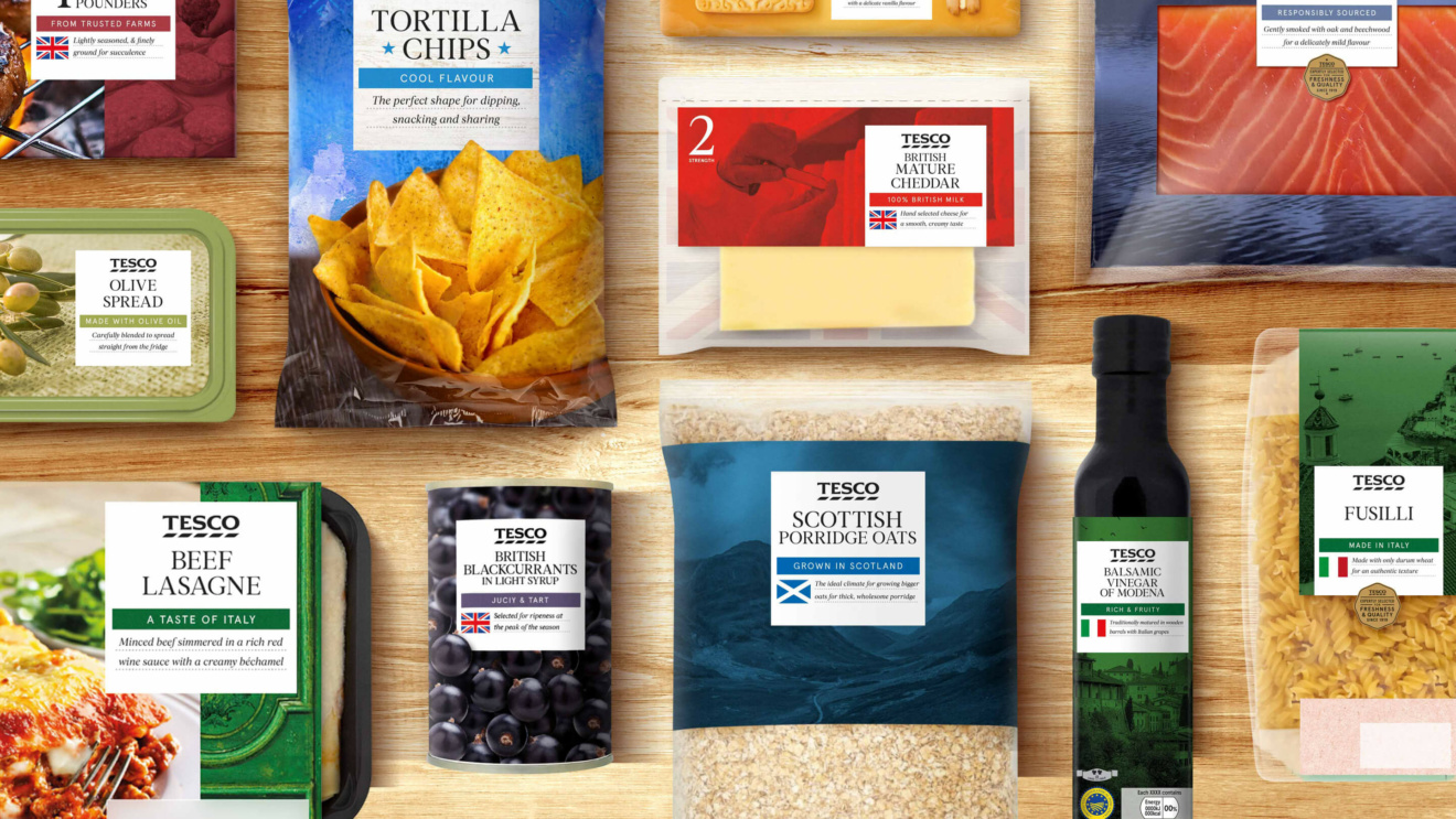 "An assortment of Tesco food products including tortilla chips, cheddar cheese, porridge oats, balsamic vinegar, and beef lasagne, arranged on a wooden surface."