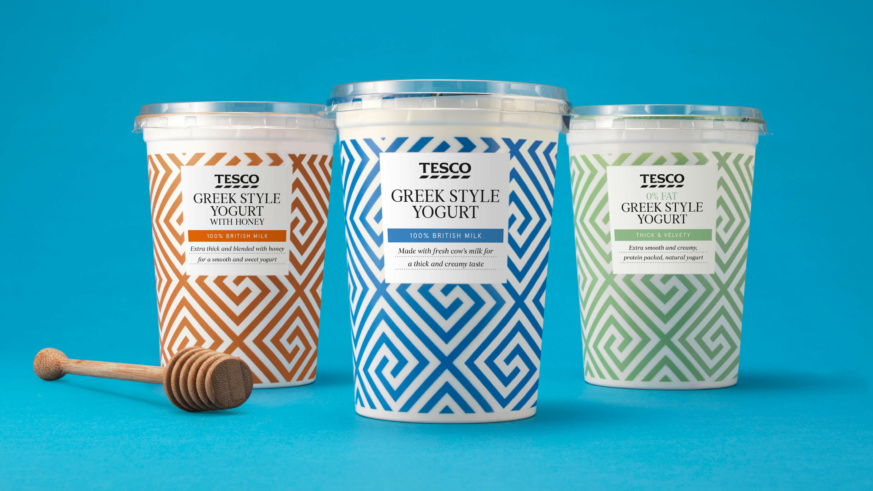 "Three tubs of Tesco Greek Style Yogurt, including a honey variant, with decorative patterns on a blue background."