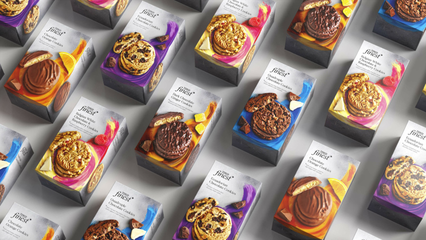 "An array of Tesco Finest cookie boxes, each with unique flavor combinations like Chocolate Orange and Belgian White Chocolate & Raspberry."