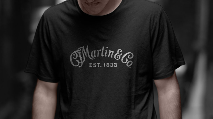 "Man wearing a black Martin Guitars T-shirt with the classic white logo."