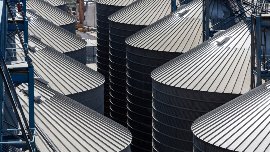 "Example of Cargill's photography princples showing rows of large, cylindrical metal silos with conical roofs, part of an industrial facility, viewed from above."