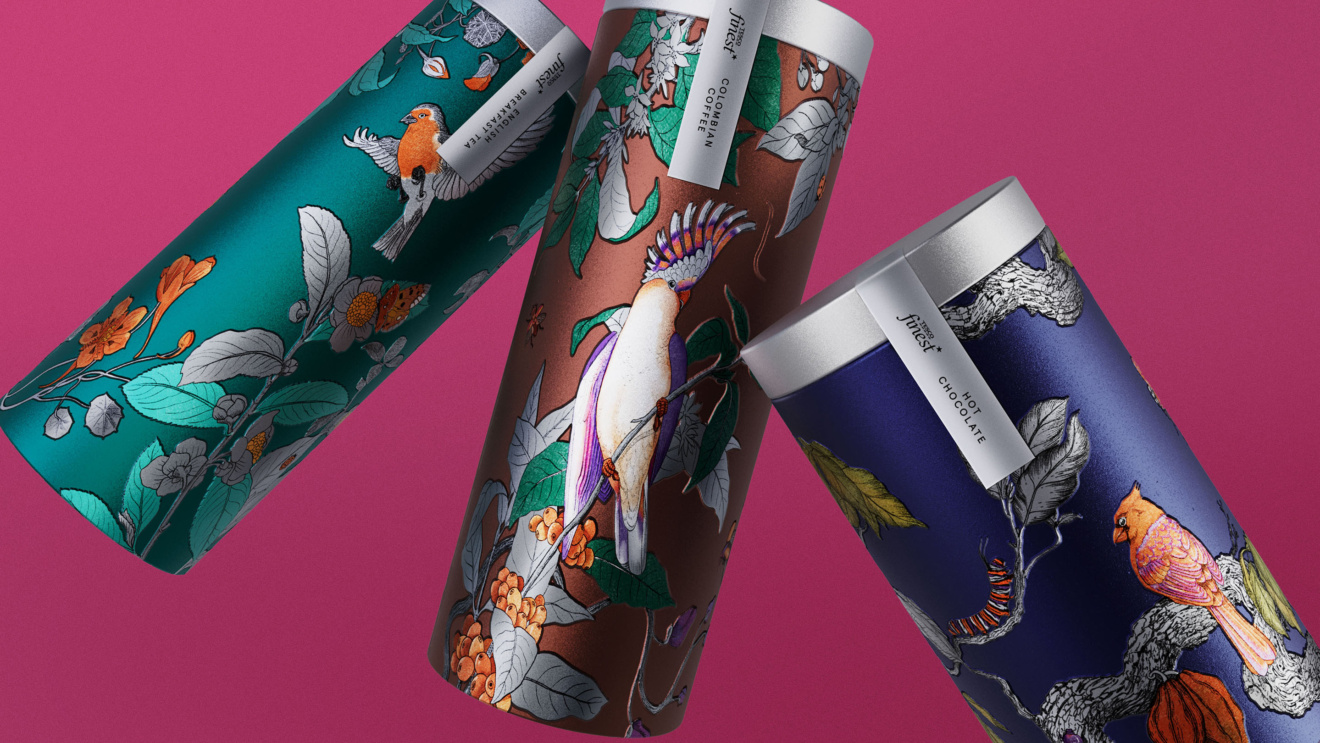 "Three cylindrical tins with intricate bird and floral designs for Tesco Finest products, including Colombian Coffee and Hot Chocolate."